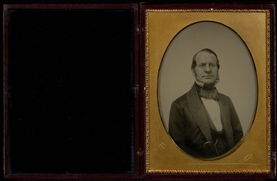 Portræt af en uidentificeret midaldrende mand med bakkenbarter og briller med trådstel af Mathew B. Brady
