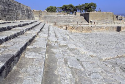 Det minoiske arkæologiske sted Phaistos. Den vestlige gård og teaterområdet. Stor brolagt domstol foran facaden og den centrale indgang til paladset (1900 -1700 f.Kr.). Denne domstol spillede en vigtig rolle i indbyggernes liv. Ved foden af af Minoan