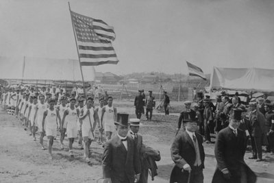Amerikanske og filippinske atleter går bag japanske dignitærer ved mesterskabskampene i Fjernøsten af Paul Thompson