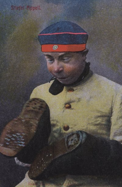 Tysk soldat ser på sålerne på sine støvler (farvet foto) af Photographer German