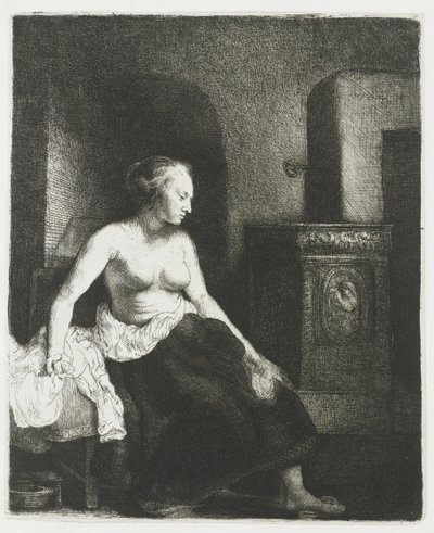 Kvinde sidder halvt påklædt ved siden af et komfur af Rembrandt van Rijn