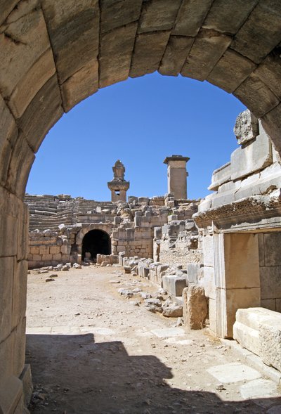 Udsigt gennem den hvælvede indgang til Xanthos-teatret ind i orkestergraven, der viser søjle og Harpy-grav, Xanthos, Tyrkiet (foto) af Roman