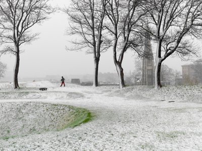 Ensom skikkelse går rundt i Københavns Befæstning i snestorm, Danmark, 2022 (foto) af Sisse Brimberg