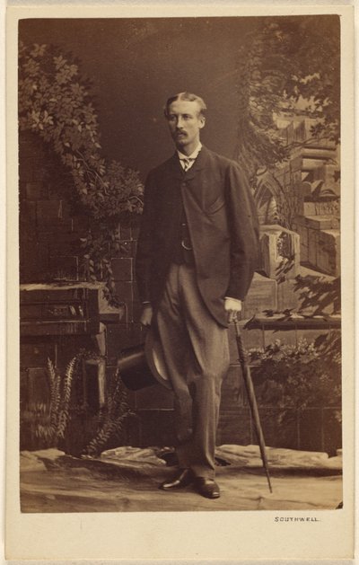 [Uidentificeret mand med overskæg, der holder en høj hat og en paraply, stående]. af Southwell Brothers