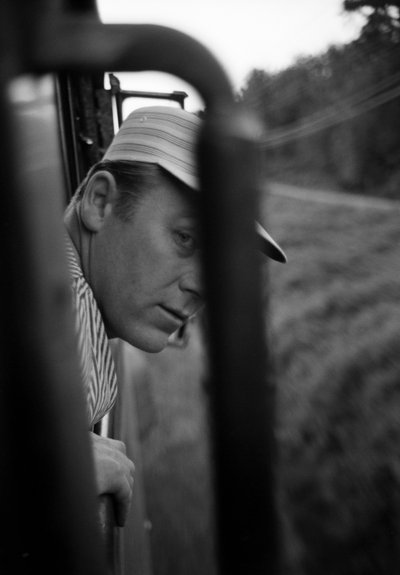 En lokomotivfører fra Great Northern Railroad kigger ud af vinduet i førerhuset på et EMD E7-lokomotiv. af Ted Spiegel