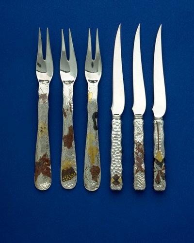 En del af et fint og sjældent sæt af 36 dessertknive og -gafler, de plethamrede håndtag indlagt med patineret kobber og farvet guld, med indgraverede detaljer af forskellige blomster-, dyre- og geometriske designs, ca. 1880 (kobber, guld) af Tiffany and Company