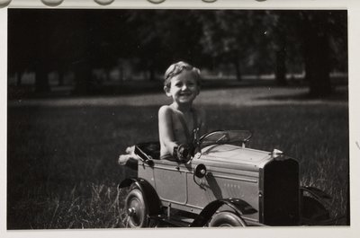 Dreng kører i en legetøjs-pedalbil, ca 1930 af Unbekannt