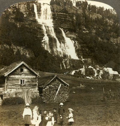 Børn leger på en bondemark med terrasseret Tvinde-vandfald, Vossevangen, Norge, c1905. af Unbekannt
