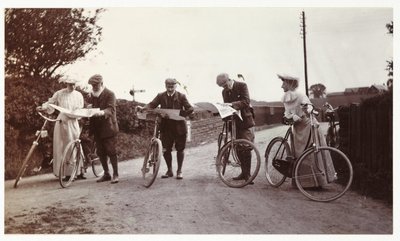Cyklister ser på kort, ca 1900 af Unbekannt