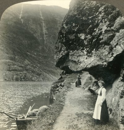 Hvor vejen kryber under de fremspringende klipper ved vandet i Nerofjorden, Norge, c1905. af Unbekannt