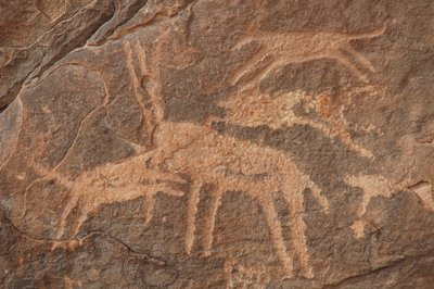 Klippekunst, forhistorie: Indgravering af en antilope angrebet af en flok hunde i Uweinat-massivet, Egypten (Periode fra 8000 til 3000 år f.Kr.). Fotografering af Unbekannt