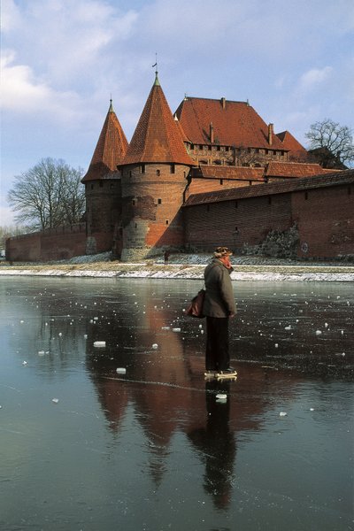 Sideprofil af en mand, der står på en frossen flod foran et slot, Nogat River, Malbork Castle, Malbork, Pomorskie Province, Polen af Benjamin Baud