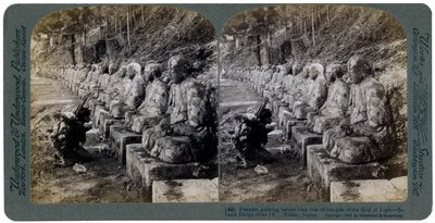 Bonde beder foran en række statuer af lysets gud, Daiya-floden, Nikko, Japan, 1904. af Underwood and Underwood