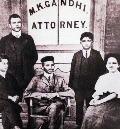 Mahatma Gandhi sidder med fire medarbejdere foran sit advokatkontor i Johannesburg, Sydafrika, Sydafrika. af Unknown photographer