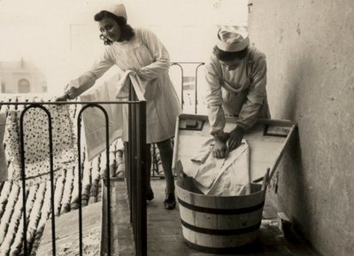 Nogle kvinder har travlt med at vaske sig på den kvindelige erhvervsskole "Regina Elena" i Imola, i dag mellemskolen "Innocenzo da Imola". af Unknown photographer