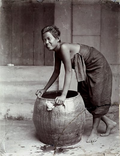 Ung smilende thailandsk kvinde skubber en stor container af Unknown photographer