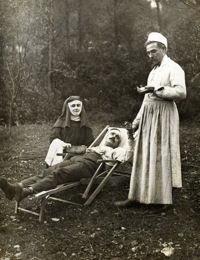 Læge tager pulsen på en såret mand, assisteret af en sygeplejerske nonne, omkring 1900 (s/h foto) af . .