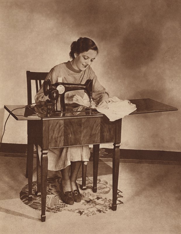 Husmor arbejder på symaskinen, midt i 1930