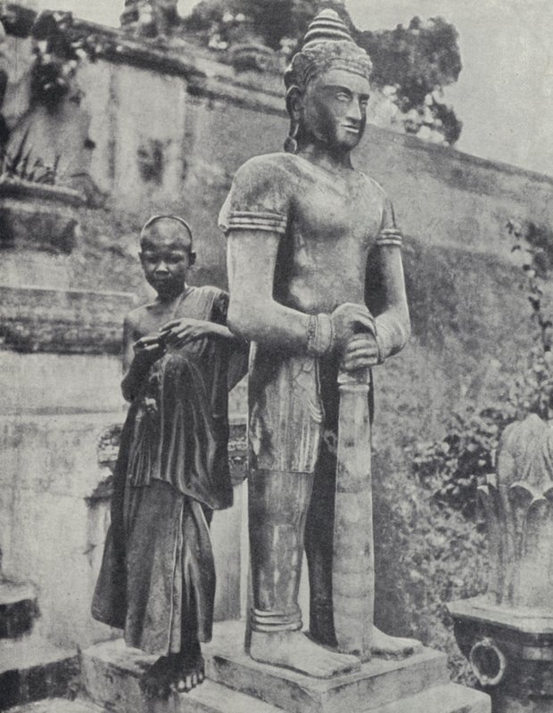 Ung buddhistisk nybegyndermunk ved siden af en statue af Buddha, Fransk Indokina (s/h-billede) af Ewing Galloway