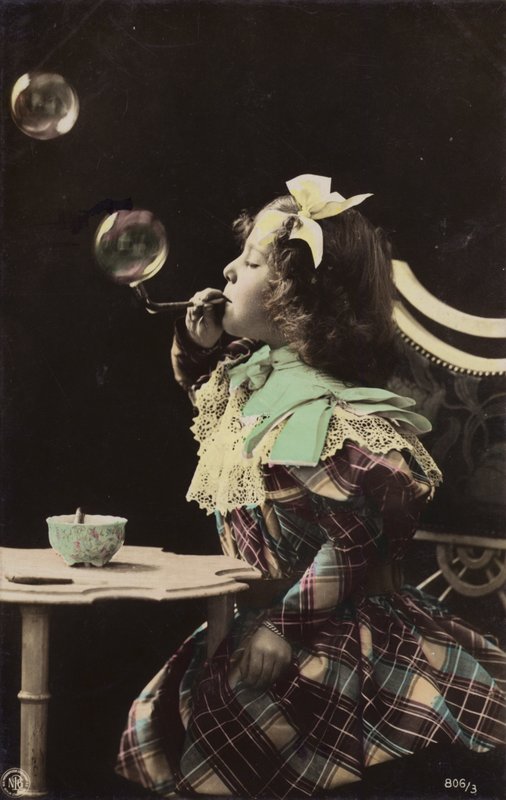 En lille pige blæser bobler fra et rør (tonet billede) af French Photographer