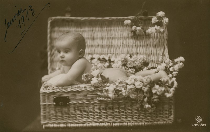 Postkort af en baby i en flettet kurv med blomster, sendt i januar 1913 af French Photographer