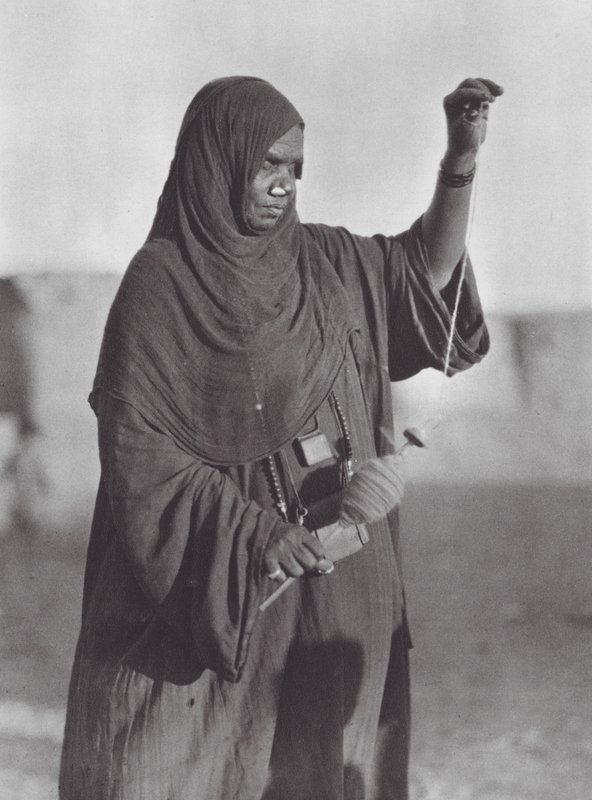 Afrika: Bisharin-kvinde spinder i den nubiske ørken (s/h-foto) af Hugo Adolf Bernatzik