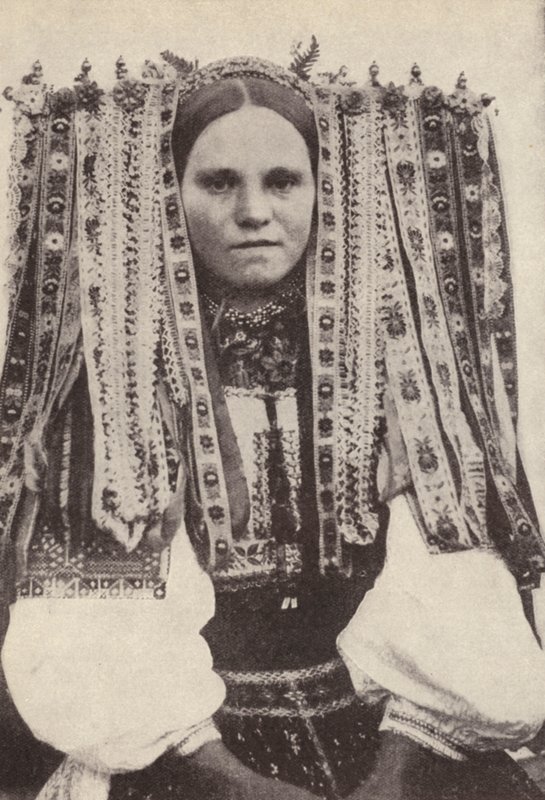 Tjekkisk kvinde iført en hovedbeklædning af bånd, hvor hvert bånd angiver en bejler, hun nægtede i ægteskab (s/h foto) af Photographer Czech