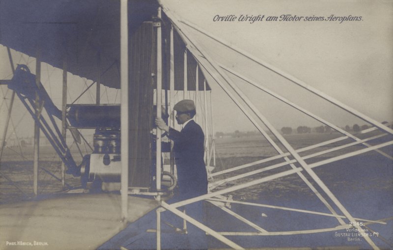 Den amerikanske flyver Orville Wright inspicerer motoren på sit fly (s/h foto) af Photographer German