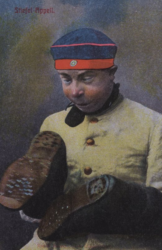 Tysk soldat ser på sålerne på sine støvler (farvet foto) af Photographer German