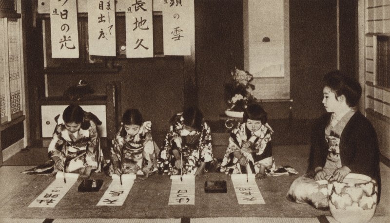 Japanske skolepiger, der skriver med pensler i en børnehaveklasse (s/h-billede) af Photographer Japanese