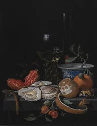 Østers, frugt og et vinglas på et stenbord