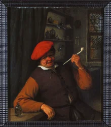 En bonde i en rød baret, der ryger pibe, i et indre