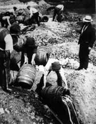 En amerikansk føderal agent fører tilsyn med ødelæggelsen af ølfade under den amerikanske forbudsperiode (1920-33) (s/h foto)