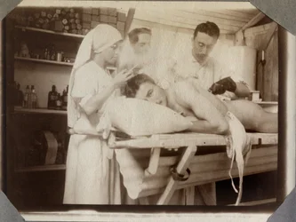 Første Verdenskrig 1914-1918: læger og en sygeplejerske behandler en soldats sår i forbindingsstuen i Couville-lejren i Manche, Nedre Normandiet, Frankrig. Anonymt fotografi, juli 1917. Stella, privatsamling.
