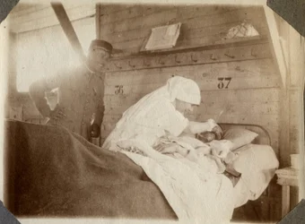 Første Verdenskrig 1914-1918: Sygeplejerske i bluse barberer en soldat (franske krigsskader ligger i en seng) i Couville, Manche, Basse-Normandiet (Basse-Normandiet), Frankrig. Anonymt fotografi juli 1917. Privatsamling, Stella.