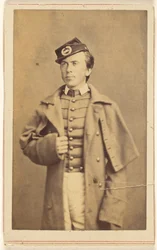 [Uidentificeret borgerkrigssoldat står med den ene hånd om sin frakke].