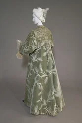 Bertha Palmers aftenfrakke, ca. 1902 (skråudsigt bagfra). Silkesatin med skåret fløjl i hvedemønster, metallic tråd blonder, silke metallic kvaster. Værd, Paris.
