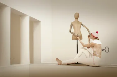 Kvinde, der vikler en mannequin ind
