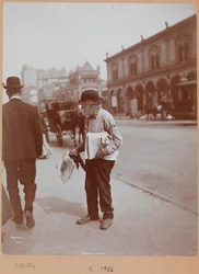En mand står på fortovet på Broadway mellem 34th St. og 35th St. med avisen The Evening Telegram i hånden