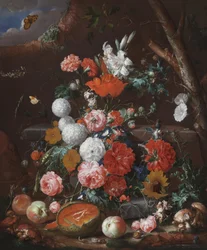 Et stilleben med blomster og frugt arrangeret på en stensokkel i en have