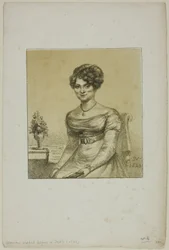 Kvinde siddende foran et bord