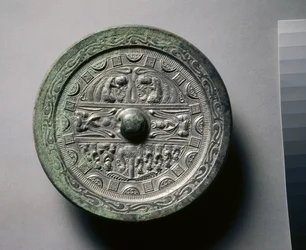 Spejl med guddomme og konger i tre sektioner omgivet af ringe af firkanter og halvcirkler (bronze)