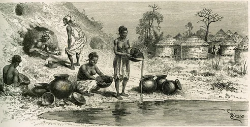 Kvinder i landsbyen Koumakhana vasker guld, i baggrunden søger mænd guld i underjordiske gallerier. Gravering af Riou, for at illustrere historien "Exploration du Haut-Niger (Haut-Niger)" (nuværende Mali) af kommandør Joseph Gallieni (1849-1916) fra