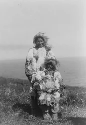 Et lille barn og en ældre eskimo iført andeskindsparkaer, Nunivak Island, Alaska, ca. 1929 (s/h-foto)