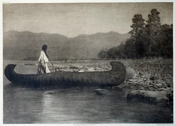 Indians of America: en indianer på en kanobåd i det sydlige Flathead Lake, Montana