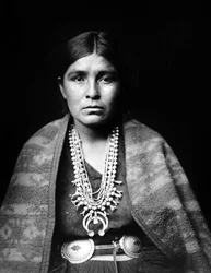 Navajo kvinde iført sølv squash blomst halskæde, concho bælte, tæppe draperet over skuldrene, ca. 1904, foto Edward S. Curtis