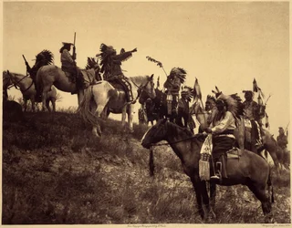 Planlægger et raid. Indianerne, i deres imponerende typiske kostumer, mødes i yderst maleriske grupper. Dette er en troppe fra Sioux Ogalala (Oglala), på en bakke med udsigt over Wounded Knee Valley i Pine Ridge Reserve, South Dakota. Foto tak