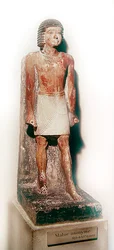 Statue af en stående mand med en hvid shenti (malet kalksten)