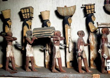 Egyptisk antikvitet: en skulptureret gruppe af malet træ, der repræsenterer tjenere, der bærer ofringer til den afdøde. Kairo, Egyptisk Museum