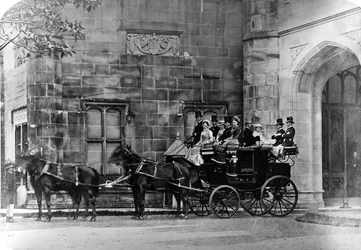Hestetrukket træner uden for et nygotisk herskabshjem, ca. 1870-90